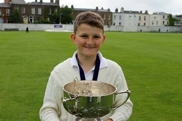 Image of a junior player holding a trophy